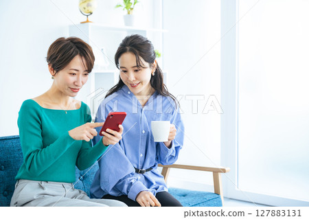 兩位女士在現代客廳看智慧型手機 127883131