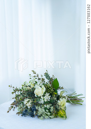 A white bouquet placed on a white table Bridal/Wedding image 127883162