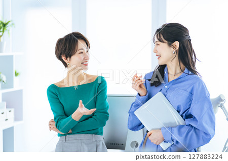 Two women having a conversation in a modern office Two women having a conversation in a modern office 127883224