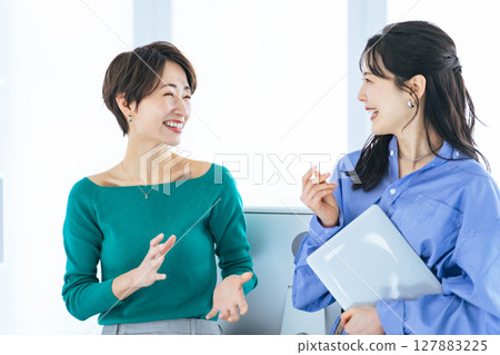 Two women having a conversation in a modern office Two women having a conversation in a modern office 127883225