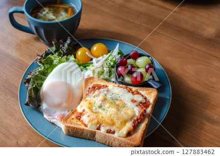 A Western-style breakfast plate with cheese toast, fried egg, and salad 127883462