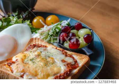 A Western-style breakfast plate with cheese toast, fried egg, and salad 127883468