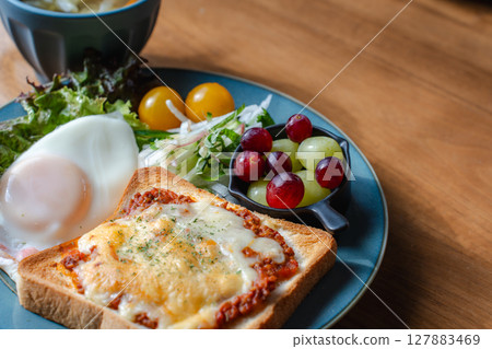A Western-style breakfast plate with cheese toast, fried egg, and salad 127883469