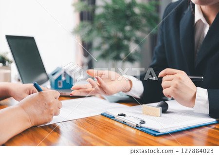 Bank approve loan to buy home concept. Real estate agent talked about terms of home purchase agreement, asked customer to sign documents to make contract legally. approved mortgage application form. 127884023