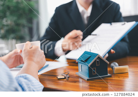 Bank approve loan to buy home concept. Real estate agent talked about terms of home purchase agreement, asked customer to sign documents to make contract legally. approved mortgage application form. 127884024