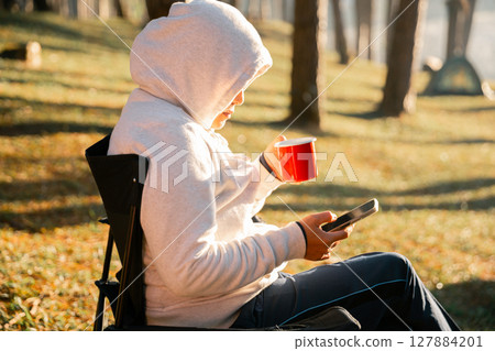 Remote work technology online close up communication smart phone laptop telephone digital travel brown nature sunlight camp beverage morning sit drink coffee tent orange outlying concept background. Remote work technology online close up communication smart phone laptop telephone digital travel brown nature sunlight camp beverage morning sit drink coffee tent orange outlying concept background. 127884201