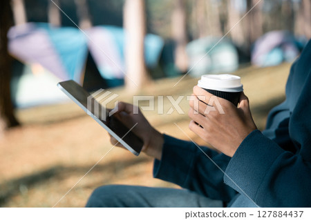 Remote work technology online close up communication smart phone laptop telephone digital travel brown nature sunlight camp beverage morning sit drink coffee tent orange outlying concept background. Remote work technology online close up communication smart phone laptop telephone digital travel brown nature sunlight camp beverage morning sit drink coffee tent orange outlying concept background. 127884437
