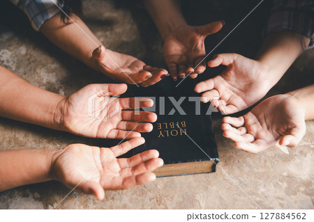 Close up group christians hands pray to God with spiritual faith on holy bible in catholic church. religion worship prayer ask god bless grace jesus believe. Christianity religion prayer holy worship 127884562