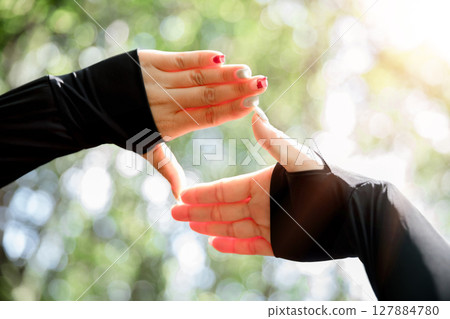 Young woman hand reaching for mountains. Spiritual girl smiling to sky. Happy female being thankful. Spiritual girl praying with hope. Positive asian young woman feeling hope and faith looking up. 127884780