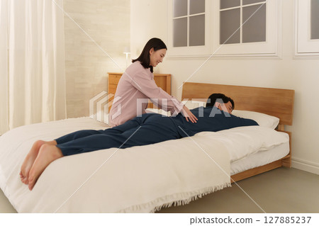 Wife giving her husband a massage Wife giving her husband a massage 127885237