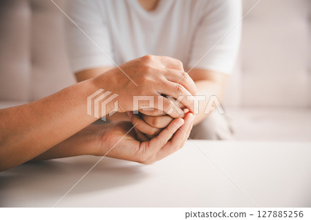 Hope and trust with crisis concept. Closeup, love and holding hands for support, comfort and care with grief, loss and empathy. people and family with compassion, sympathy and healing with bonding. Hope and trust with crisis concept. Closeup, love and holding hands for support, comfort and care with grief, loss and empathy. people and family with compassion, sympathy and healing with bonding. 127885256