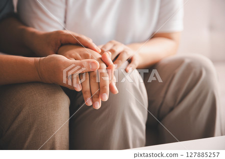 Hope and trust with crisis concept. Closeup, love and holding hands for support, comfort and care with grief, loss and empathy. people and family with compassion, sympathy and healing with bonding. 127885257
