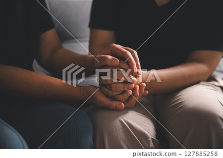 Hope and trust with crisis concept. Closeup, love and holding hands for support, comfort and care with grief, loss and empathy. people and family with compassion, sympathy and healing with bonding. 127885258