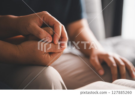 Hope and trust with crisis concept. Closeup, love and holding hands for support, comfort and care with grief, loss and empathy. people and family with compassion, sympathy and healing with bonding. Hope and trust with crisis concept. Closeup, love and holding hands for support, comfort and care with grief, loss and empathy. people and family with compassion, sympathy and healing with bonding. 127885260