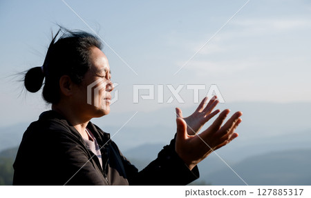 Grateful woman having HOPE praying to God. Spiritual girl smiling to sky. Happy female being thankful. Spiritual girl praying with hope. Positive asian young woman feeling hope and faith looking up. 127885317