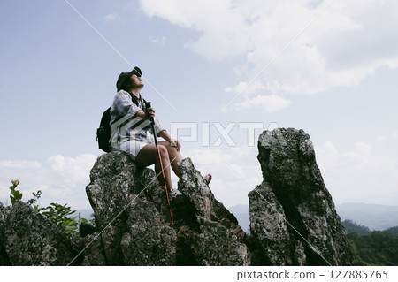 Woman hiker on top of mountain. Hiker with arms up on top of mountain successful young woman enjoying triumph. traveler exploring world. Hikers with backpacks relaxing. Sport and success concept. Woman hiker on top of mountain. Hiker with arms up on top of mountain successful young woman enjoying triumph. traveler exploring world. Hikers with backpacks relaxing. Sport and success concept. 127885765