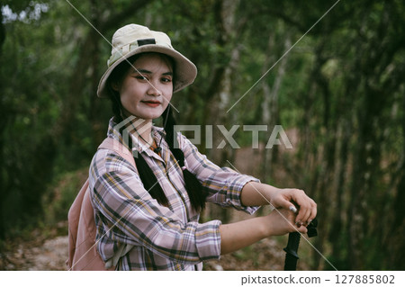 Young female traveler with backpack walking in national park or forest. recreation sport in nature. Female person bag, wave for hiking journey in woods. adventure in forest. trekking with backpack Young female traveler with backpack walking in national park or forest. recreation sport in nature. Female person bag, wave for hiking journey in woods. adventure in forest. trekking with backpack 127885802