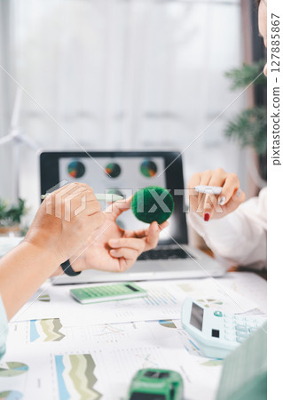 Business people working on sustainable innovation project. renewable energy concept. Teamwork Meeting, partner on model building company office technology, based green businesses and global warming. 127885867