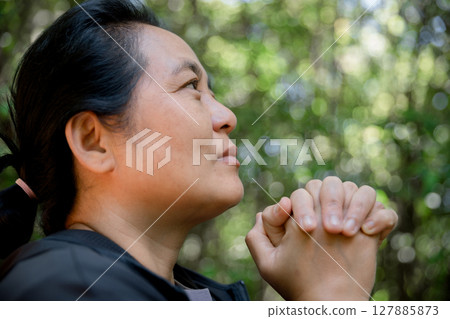 Grateful woman having HOPE praying to God. Spiritual girl smiling to sky. Happy female being thankful. Spiritual girl praying with hope. Positive asian young woman feeling hope and faith looking up. 127885873