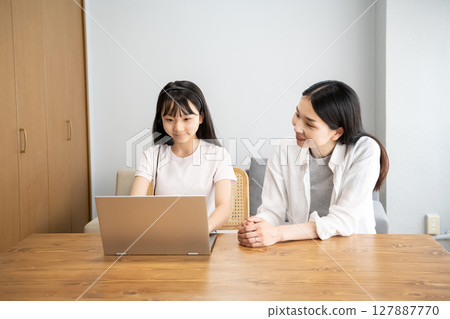 Mother and daughter using a laptop Mother and daughter using a laptop 127887770