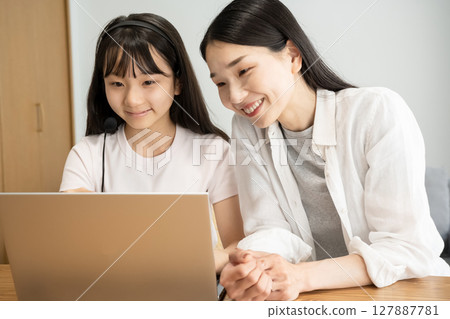 Mother and daughter using a laptop 127887781
