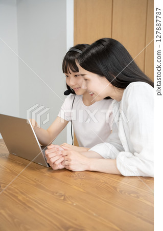 Mother and daughter using a laptop Mother and daughter using a laptop 127887787