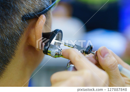 Patient is seen by an otolaryngologist. ENT doctor examines a patient. An otolaryngologist examines a patient's inner ear using an otoscope. Treatment of inflammation disease of ears Patient is seen by an otolaryngologist. ENT doctor examines a patient. An otolaryngologist examines a patient's inner ear using an otoscope. Treatment of inflammation disease of ears 127887848