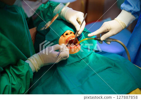 Dentist at work or Concentrated specialist removing tooth stone from client's teeth using ultrasonic scaler. Professional painless teeth cleaning at modern dental 127887858