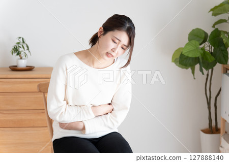 A woman holding her stomach with stomachache 127888140