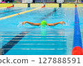 Swimmer child swims butterfly swimming style in a race swimming pool. Water sports and competition, learning to swim classes for children. 127888591