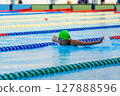Swimmer child swims butterfly swimming style in a race swimming pool. Water sports and competition, learning to swim classes for children. 127888596