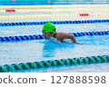 Swimmer child swims butterfly swimming style in a race swimming pool. Water sports and competition, learning to swim classes for children. 127888598