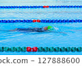 Swimmer child swims backstroke swimming style in a race swimming pool. Water sports and competition, learning to swim classes for children. 127888600