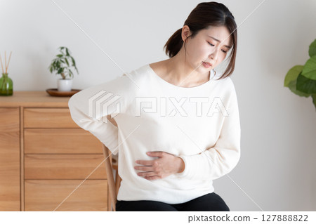 身體不適的女人摀著肚子和背部 127888822