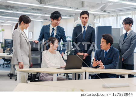 Office workers working very cheerfully as team members 127888944