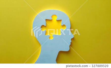 A white paper silhouette of a head with a missing puzzle piece, depicting the idea of mental health and emotional wellness 127889320