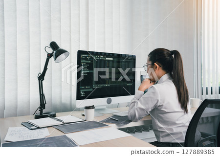 Asian female software developer is worried about analyzing code-based systems at his office. Asian female software developer is worried about analyzing code-based systems at his office. 127889385
