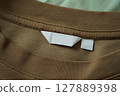 Close up of blank white clothing care label on shirt fabric background. 127889398