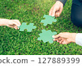 group of business people assembling jigsaw puzzle. The concept of cooperation, teamwork, help and support in business. 127889399