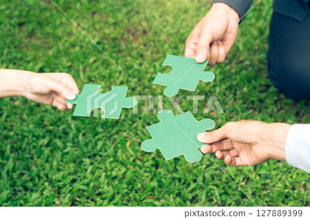 group of business people assembling jigsaw puzzle. The concept of cooperation, teamwork, help and support in business. 127889399