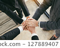Close up of group of business people joining their hands together in unity. 127889407