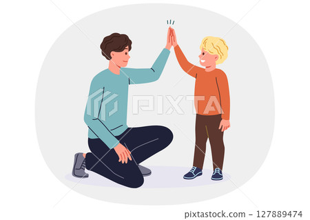 Father supports young son by high-fiving boy and raising child on own after divorce from mother. Father supports young son by high-fiving boy and raising child on own after divorce from mother. 127889474