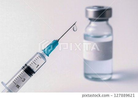 Sterile medical syringe with droplet and vaccine vial on soft white background Sterile medical syringe with droplet and vaccine vial on soft white background 127889621