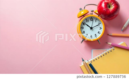 Colorful school supplies and an alarm clock on a pink background, illustrating a dynamic and engaging school environment 127889736