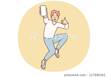 Encouraged man jumps up with mobile phone in hands showing blank screen gadget and shows thumbs up 127890362