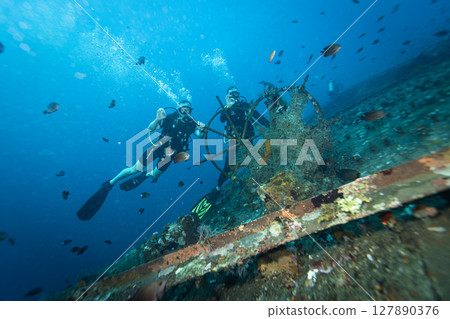 Two Divers Explores the Relax Wreck at Dive Site on the Island of Bali, Indonesia. 127890376