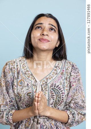 Serious desperate person praying to jesus christ with folded hands in studio, looking up and talking to god. Young faithful religious girl showing her spiritual belief, devotion and respect. Serious desperate person praying to jesus christ with folded hands in studio, looking up and talking to god. Young faithful religious girl showing her spiritual belief, devotion and respect. 127891466