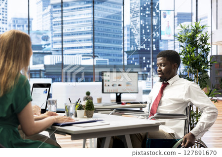 HR worker implementing diversity and inclusivity recruitment strategy for company, hiring person with paraplegia. Recruiter reaching agreement with african american wheelchair user 127891670