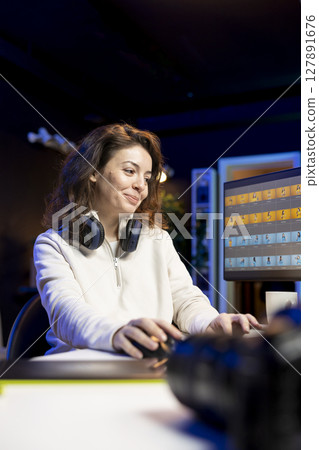 Upbeat photographer using professional photo editing tools on PC. Joyous photo editor utilizing high tech photographs retouching application to make adjustments on computer screen 127891676