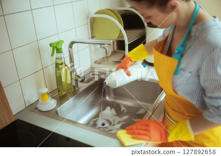 Woman Pouring Liquid into Sink 127892658